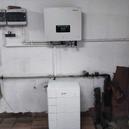 Nortmar Oddział Opole - Instalacja magazynu energii Amass w Opolu, widoczny inwerter Sofar Solar, białe rury instalacyjne i skrzynki elektryczne na tle surowej ściany.