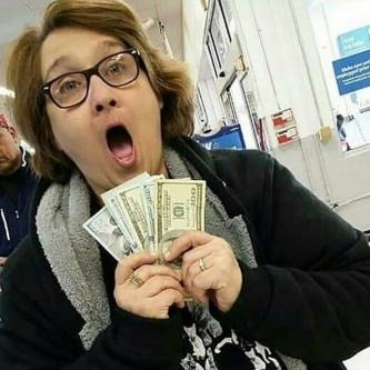 Osoba z otwartymi ustami i okularami trzymająca w dłoniach plik banknotów dolarowych, w tle widoczny zarys sklepu.