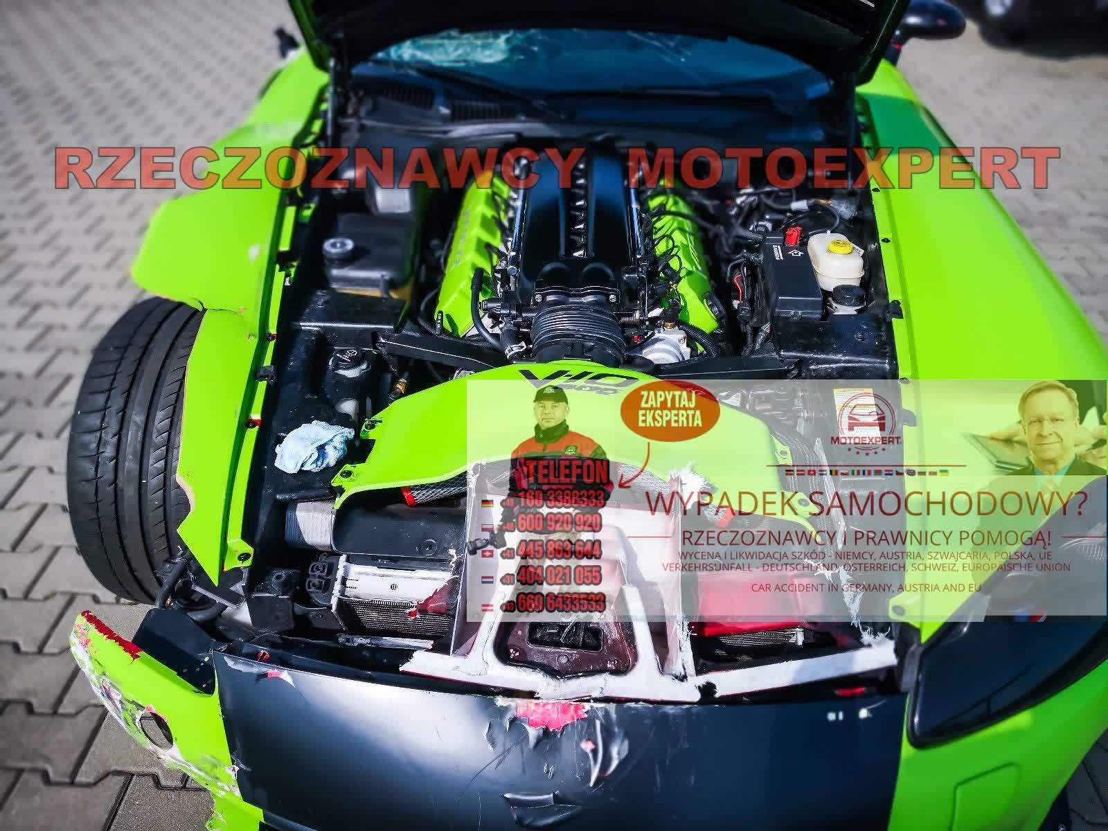 Uszkodzony, jaskrawozielony sportowy samochód z otwartą maską, ukazujący silnik; widoczne elementy karoserii z uszkodzeniami po wypadku; naklejki reklamujące usługi rzeczoznawcy samochodowego...
