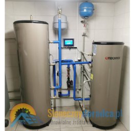 Słoneczny Doradca PL Sp. z o.o. - Dwa pionowe zbiorniki buforowe TECHINIX w kotłowni, połączone niebieskimi rurami instalacji grzewczej, z widocznym panelem sterowania systemem i naczyniami wzbiorczymi.