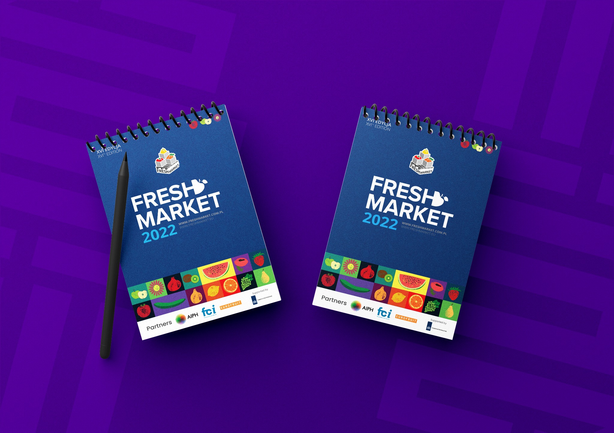 Dwa identyczne kalendarze spiralne Fresh Market 2022 na fioletowym tle z czarnym rysikiem po lewej stronie, prezentujące logo, adres strony internetowej oraz grafiki owoców i warzyw.