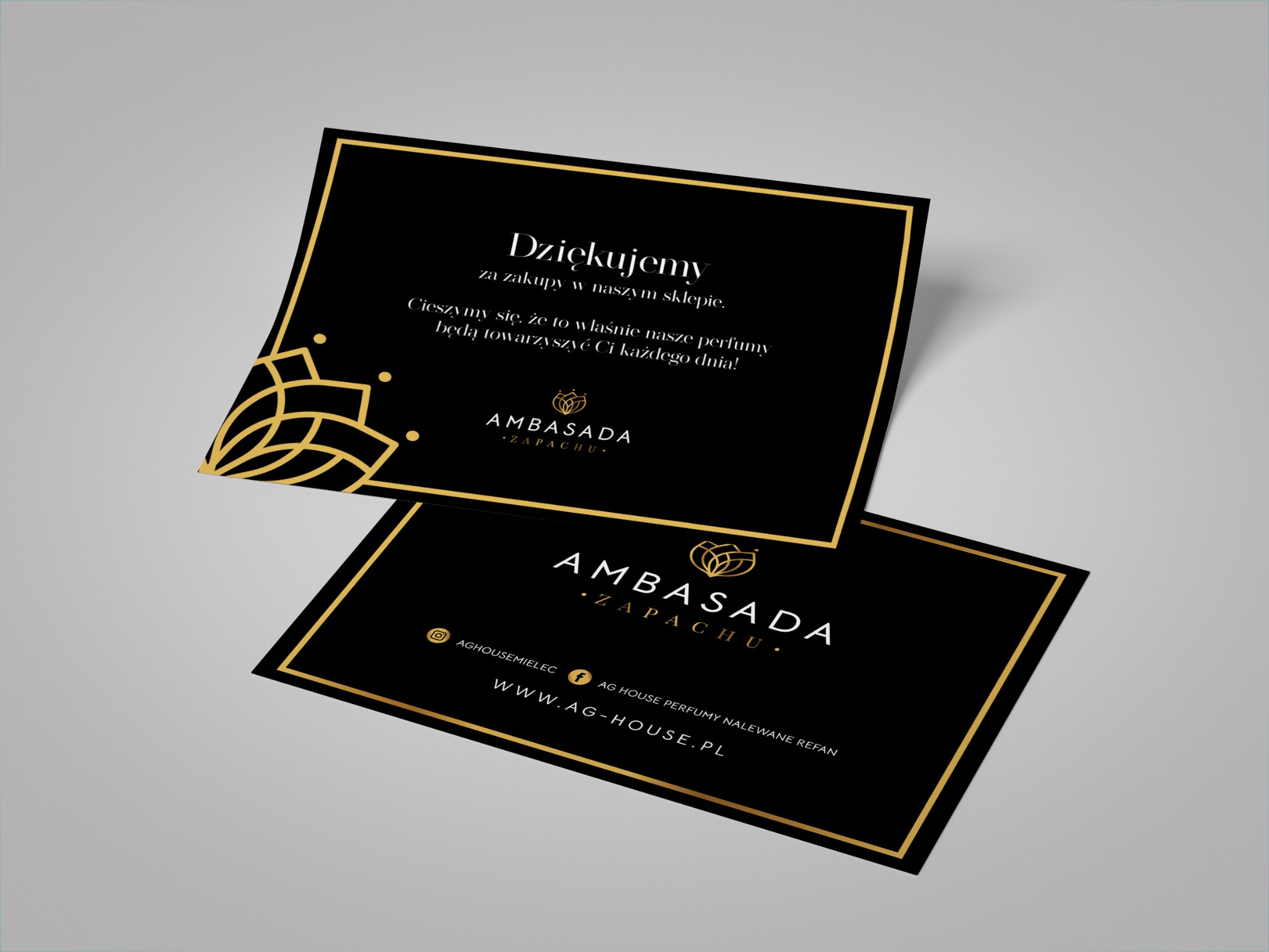 Dwie czarno-złote karty z podziękowaniami i danymi kontaktowymi firmy perfumeryjnej Ambasada Zapachu, leżące na jasnoszarym tle.