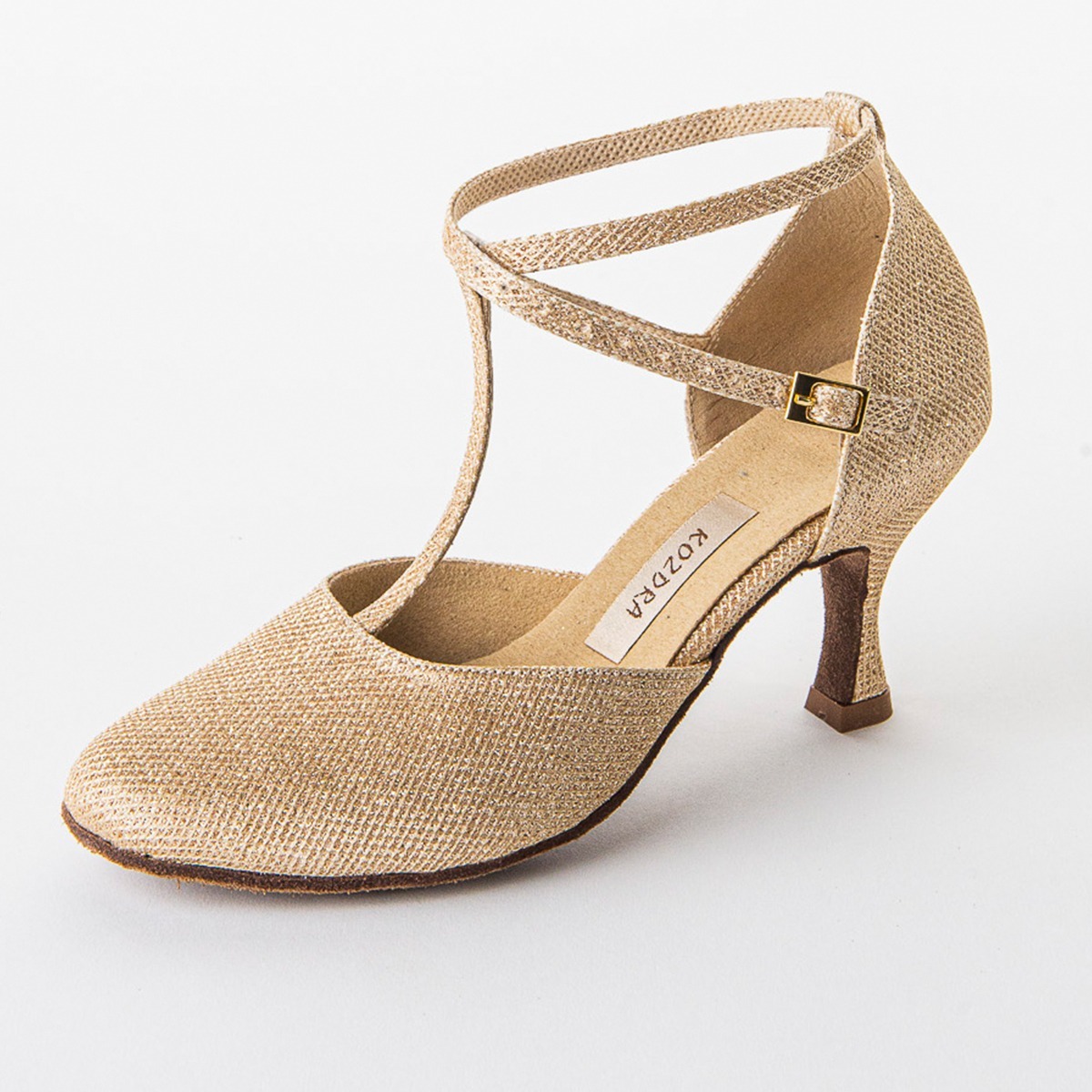 Złoty brokatowy but do tańca z paskami na białym tle, widoczna metka z nazwą producenta wewnątrz buta.