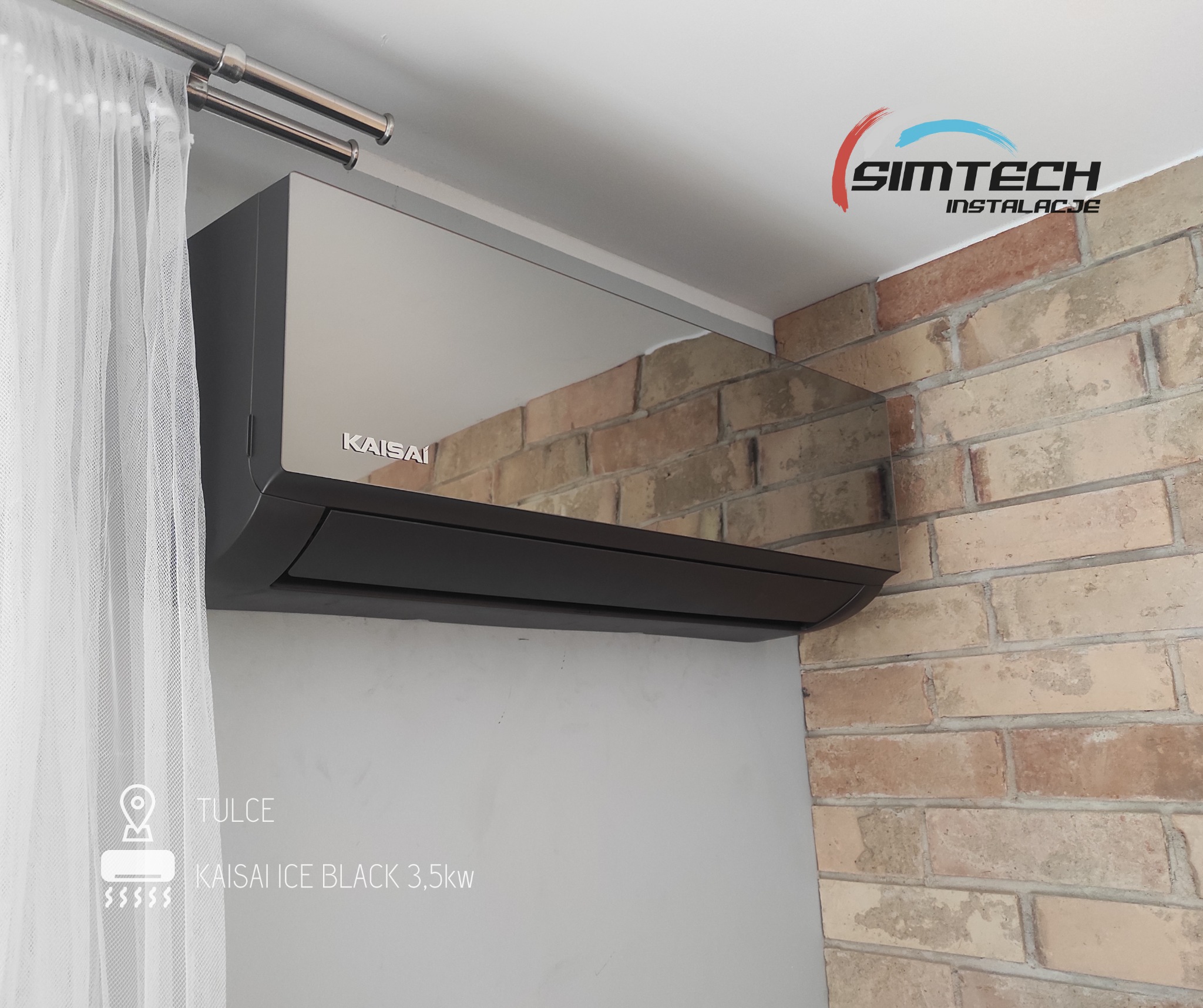 Czarny klimatyzator Kaisai Ice Black 3,5kW zamontowany w rogu pokoju, widoczna ściana z cegły i firanka, logo firmy Simtech Instalacje w prawym górnym rogu.