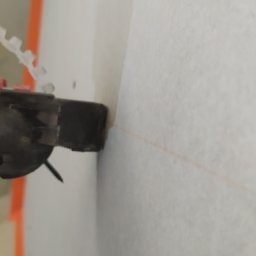 Usługi Ogólnobudowlane Michał Ruszyński - Przybliżenie narzędzia do montażu płyt gipsowo-kartonowych, widoczna linia wyznaczająca poziom na ścianie.