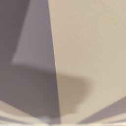 Usługi Ogólnobudowlane Michał Ruszyński - Fragment ściany pomalowanej w pionowe pasy w odcieniach szarości i beżu, widoczne z dołu, z dolną krawędzią ściany i kawałkiem podłogi w tle.