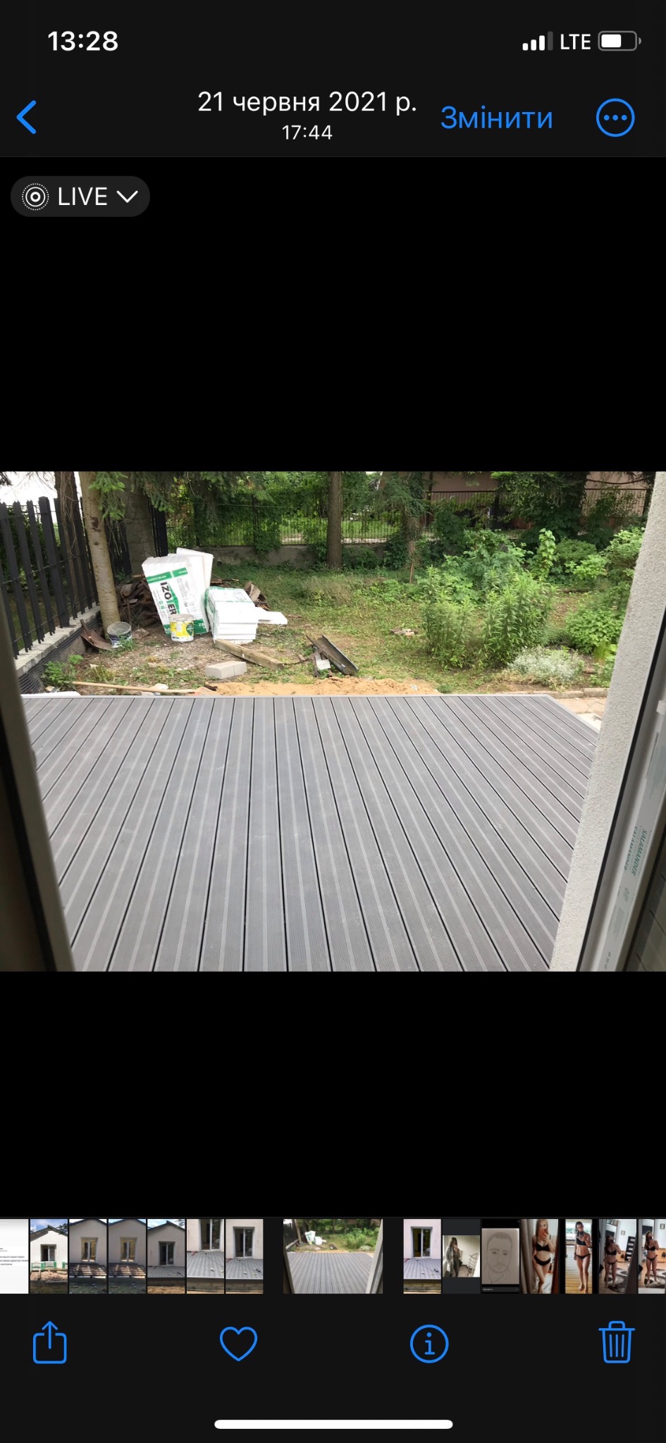 Szara deska kompozytowa tarasu, widok z wnętrza przez otwarte okno, materiały izolacyjne Izoter w tle ogrodu.