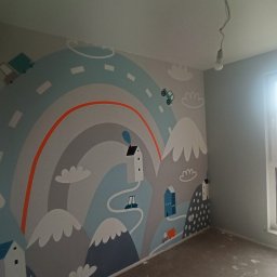 DOBRO-BUD OLEH LANOVENKO - Pokój dziecięcy po malowaniu ścian z motywem gór, dróg i domków w pastelowych kolorach. Widoczne okno z jasnym światłem dziennym.