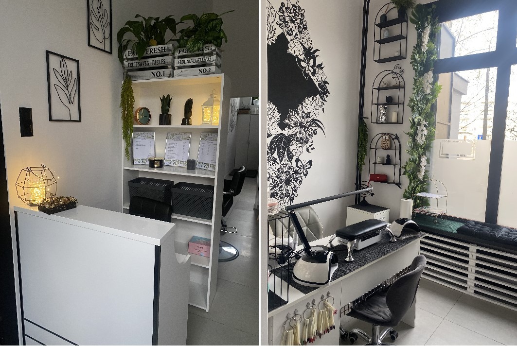 Jasne wnętrze salonu kosmetycznego z recepcją, regałem z dekoracjami i stanowiskiem do stylizacji paznokci z lampą UV i wzornikami kolorów, ozdobione motywem kwiatowym na ścianie.