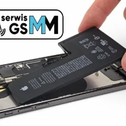 Wymiana baterii w smartfonie. Widoczna otwarta obudowa telefonu z elementami elektroniki oraz dłoń wkładająca nową baterię. Na baterii widoczne logo Apple oraz oznaczenia ostrzegawcze.