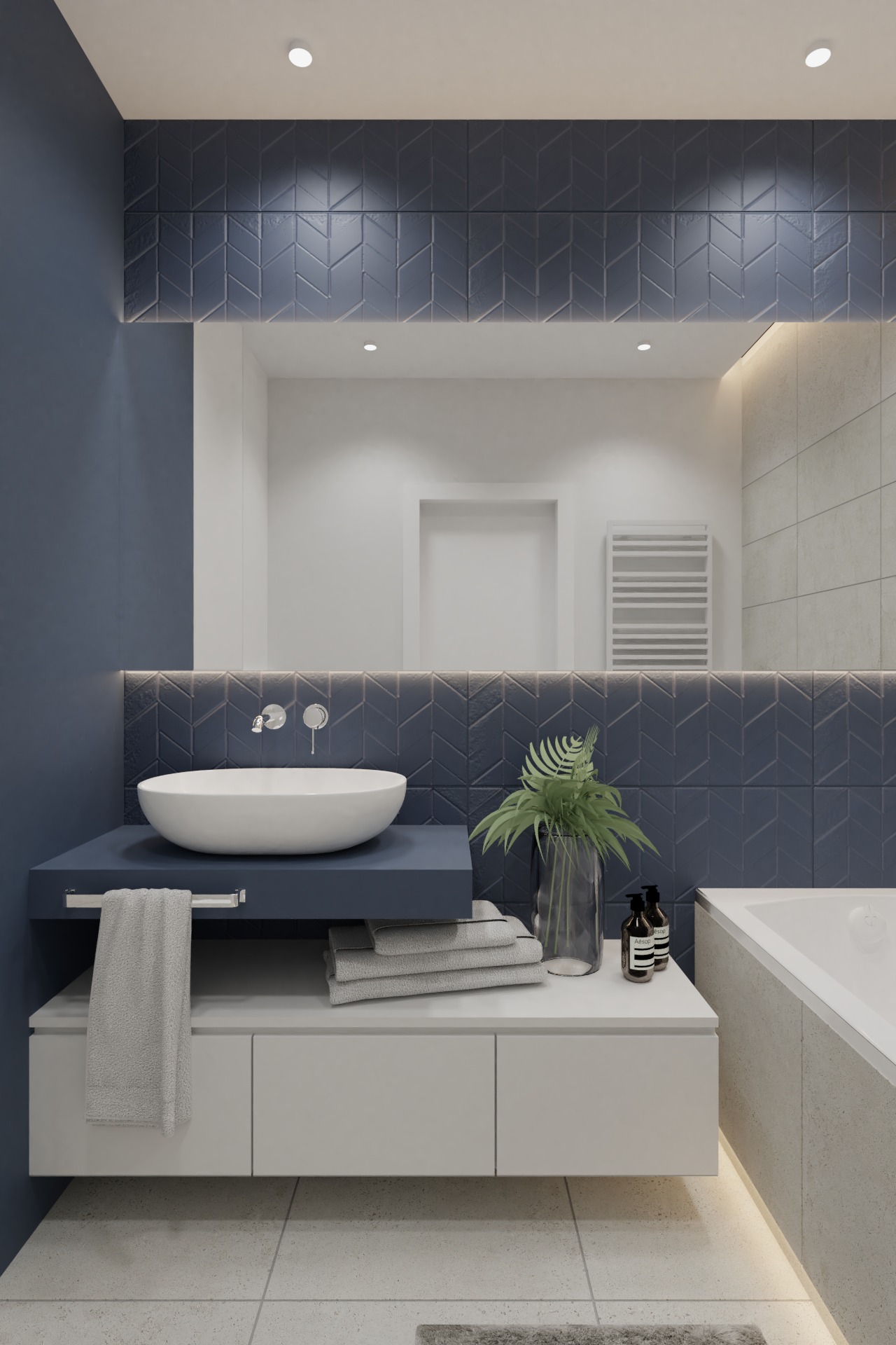 Nowoczesna łazienka z umywalką nablatową, niebieskimi płytkami ułożonymi w jodełkę, szarymi ręcznikami, rośliną w szklanym wazonie i podświetleniem LED pod szafką oraz wanną.