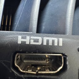 PIK Piotr Dziemiński - Port HDMI w czarnej obudowie urządzenia, widoczne detale złącza i napis HDMI. Makro, ostre światło podkreśla fakturę plastiku.