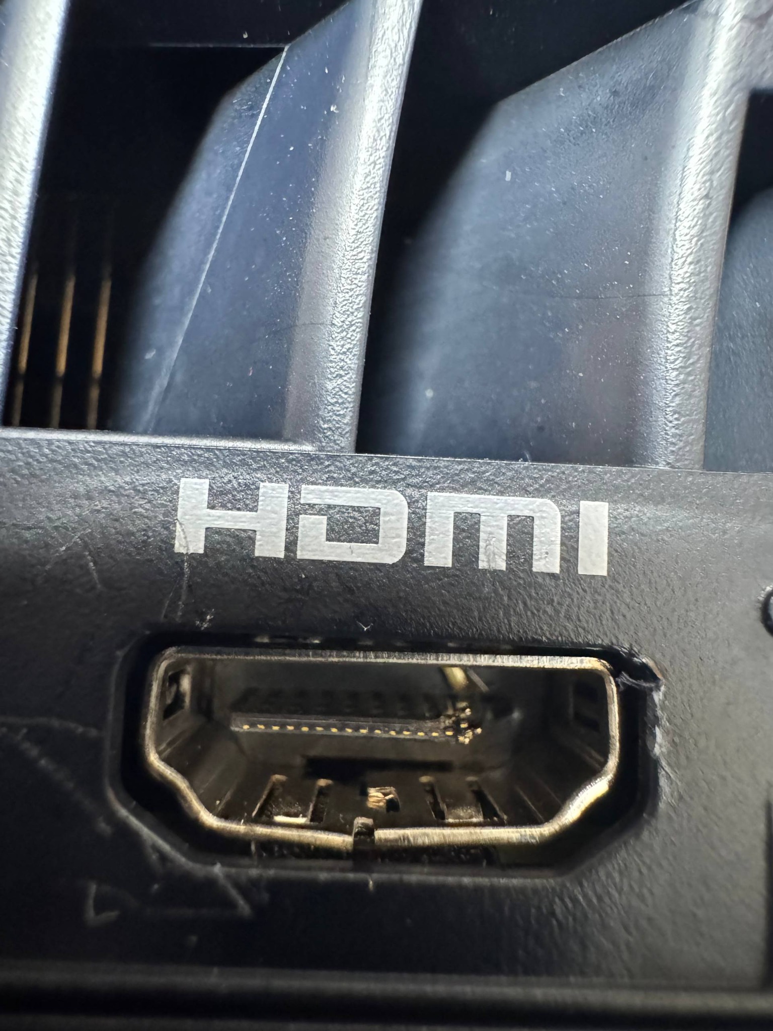 Port HDMI w czarnej obudowie urządzenia, widoczne detale złącza i napis HDMI. Makro, ostre światło podkreśla fakturę plastiku.