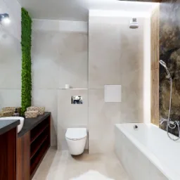 Nowoczesna łazienka z beżowymi płytkami, drewnianymi akcentami i pionową ścianą z mchu obok lustra, z wiszącą toaletą i białą wanną.