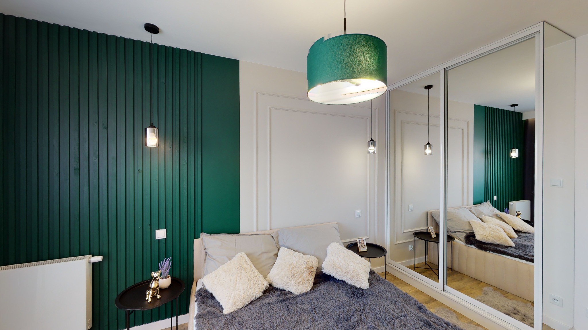 Sypialnia w odcieniach zieleni i szarości z dekoracyjną ścianą z paneli, minimalistycznymi lampami wiszącymi i szafą z lustrzanymi drzwiami przesuwnymi.