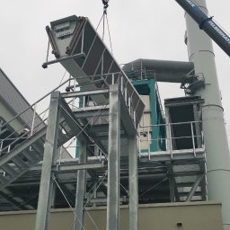 HR-MONT Service - Montaż przemysłowej instalacji wentylacyjnej na zewnątrz budynku, widoczny dźwig Felbermayr podnoszący element konstrukcyjny.