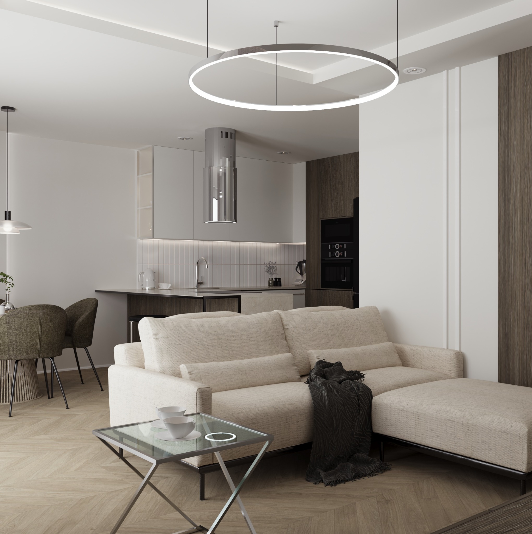 Salon z aneksem kuchennym w neutralnych barwach, beżowa sofa z pufem i czarnym pledem, szklany stolik kawowy z białymi filiżankami, okrągła lampa sufitowa.