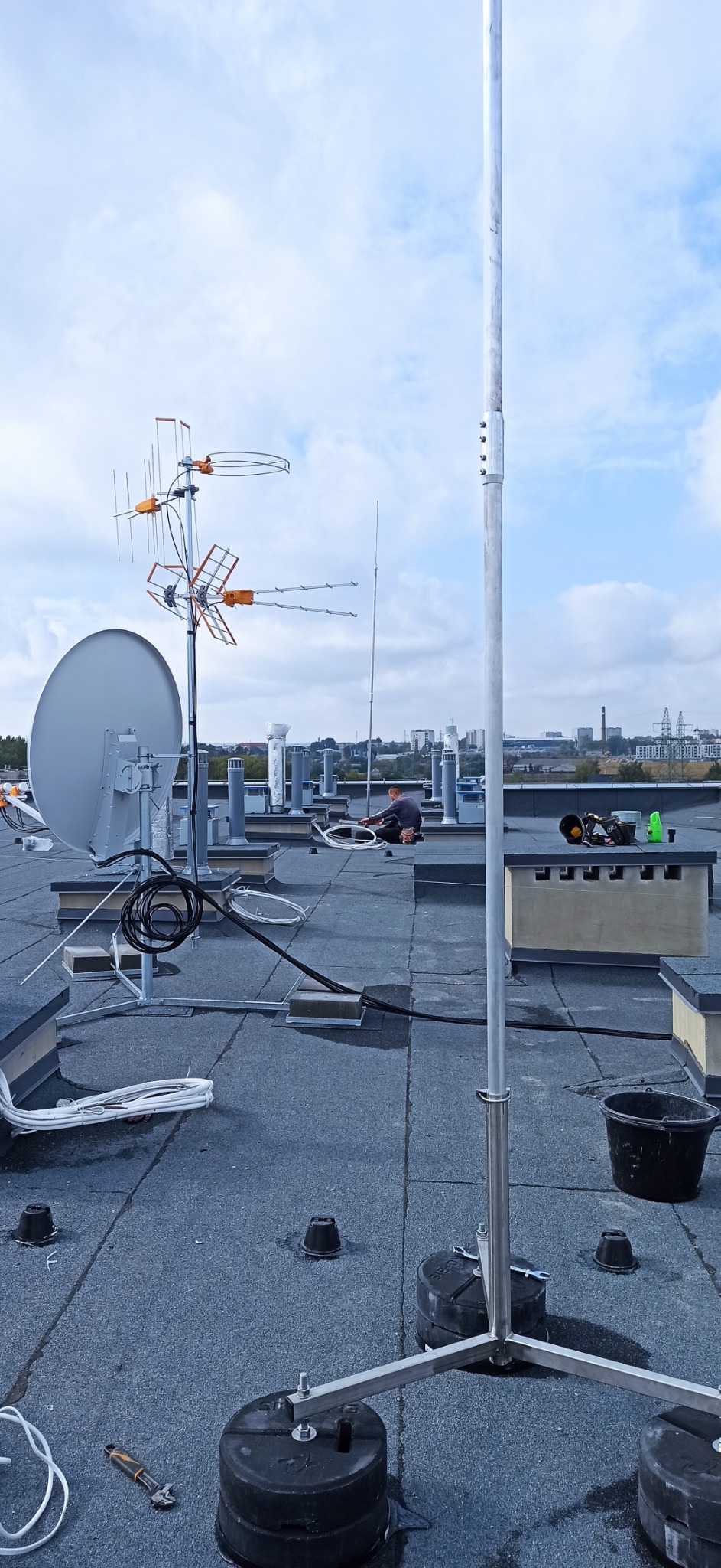 Montaż infrastruktury elektrycznej na dachu budynku wielorodzinnego. Na zdjęciu Instalacje odgromowe i teletechniczne.