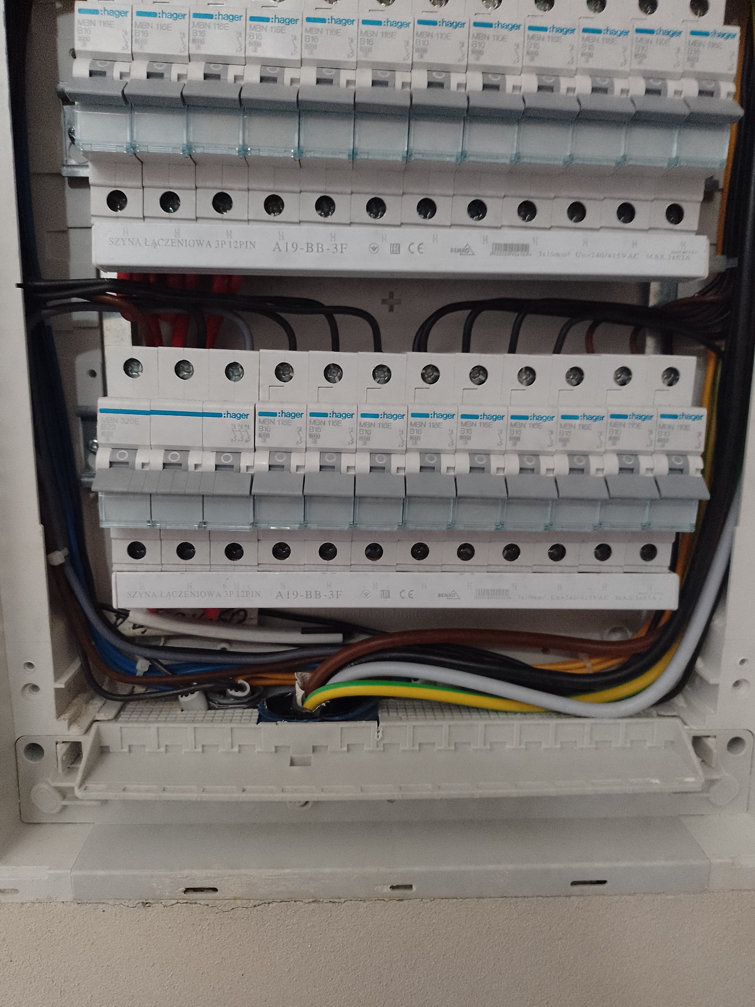 Rozdzielnica elektryczna z zainstalowanymi bezpiecznikami Hager MBN 116E B16, szynami łączeniowymi 3P 12PIN A19-BB-3F i okablowaniem wewnątrz skrzynki.