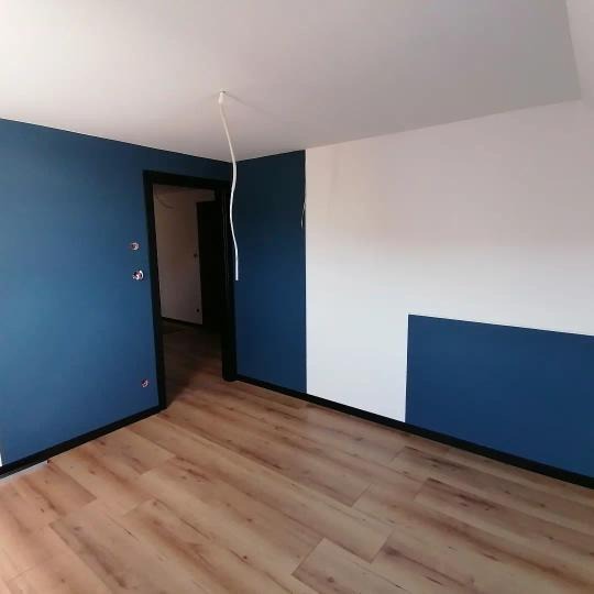 Pomieszczenie po malowaniu, z fragmentem ściany pomalowanym na biało i niebiesko, drewnopodobna podłoga, widoczne wystające kable ze ściany.