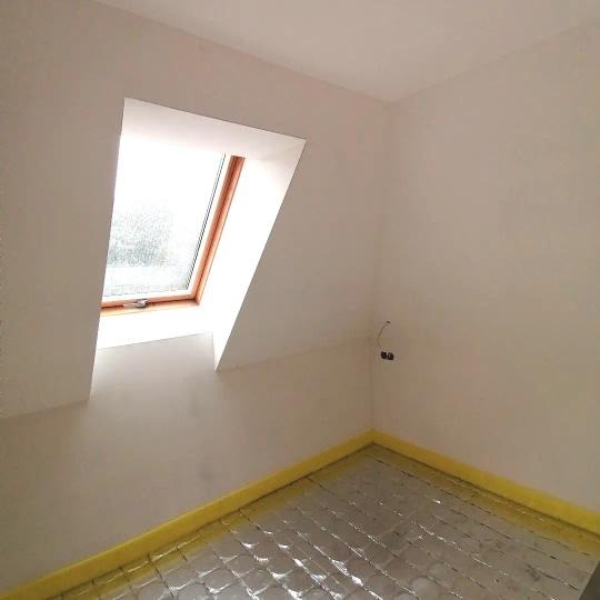 Przygotowanie podłoża podłogowego w pokoju na poddaszu z oknem dachowym, widoczna folia aluminiowa izolacyjna na podłodze i żółta taśma uszczelniająca przy ścianach.