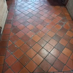 Mieczkowski Budownictwo - Podłoga wyłożona terakotą w kwadraty ułożone romboidalnie z ciemniejszą bordiurą, widoczne ślady użytkowania.