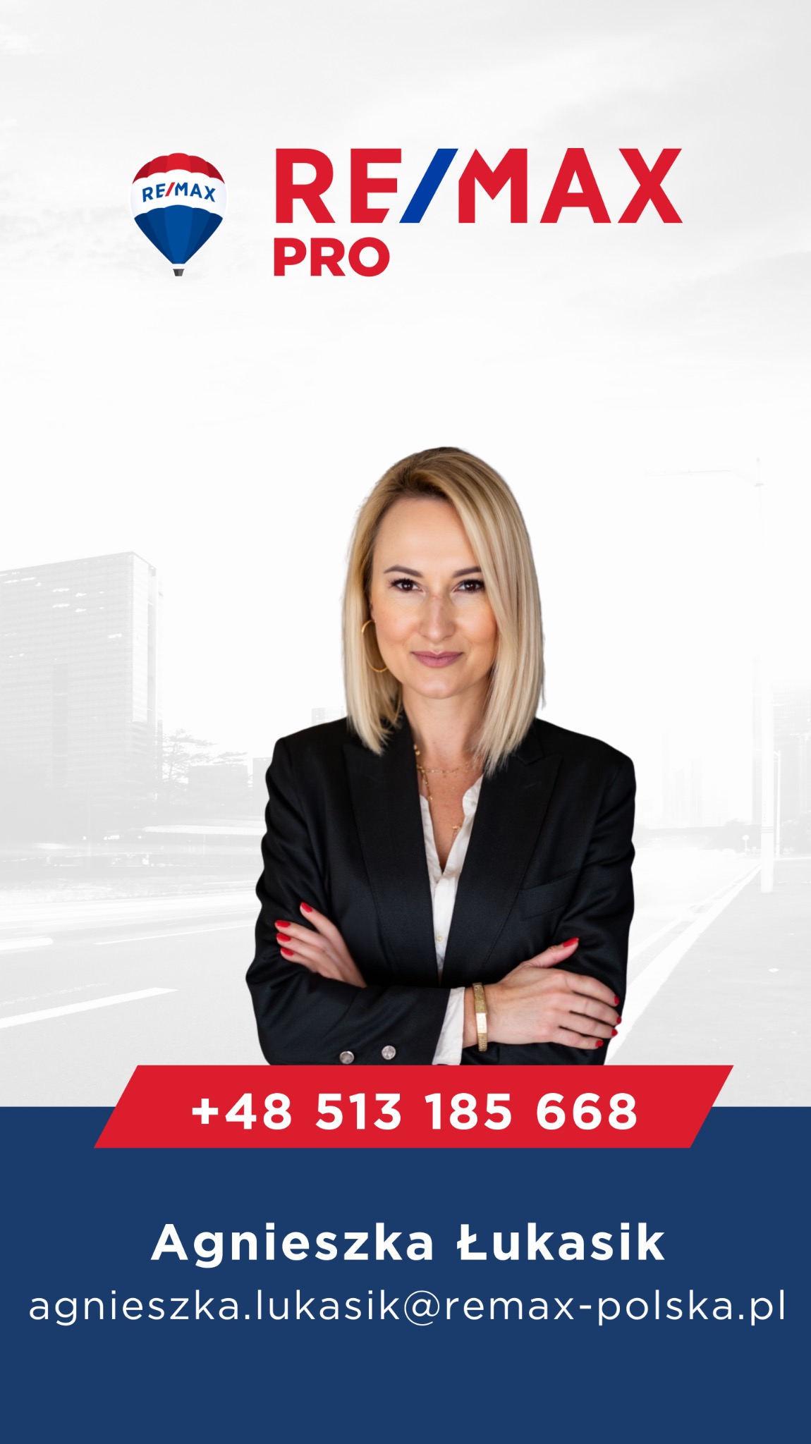 Profesjonalny portret kobiety w czarnej marynarce z logo RE/MAX Pro, numerem telefonu i adresem e-mail na tle miejskiego krajobrazu. Uśmiechnięta agentka nieruchomości.