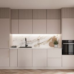 InterSpace Design - Nowoczesna kuchnia z beżowymi szafkami, marmurowym blatem i czarną armaturą, oświetlona listwą LED pod szafkami wiszącymi, z drewnianą podłogą ułożoną w jodełkę.