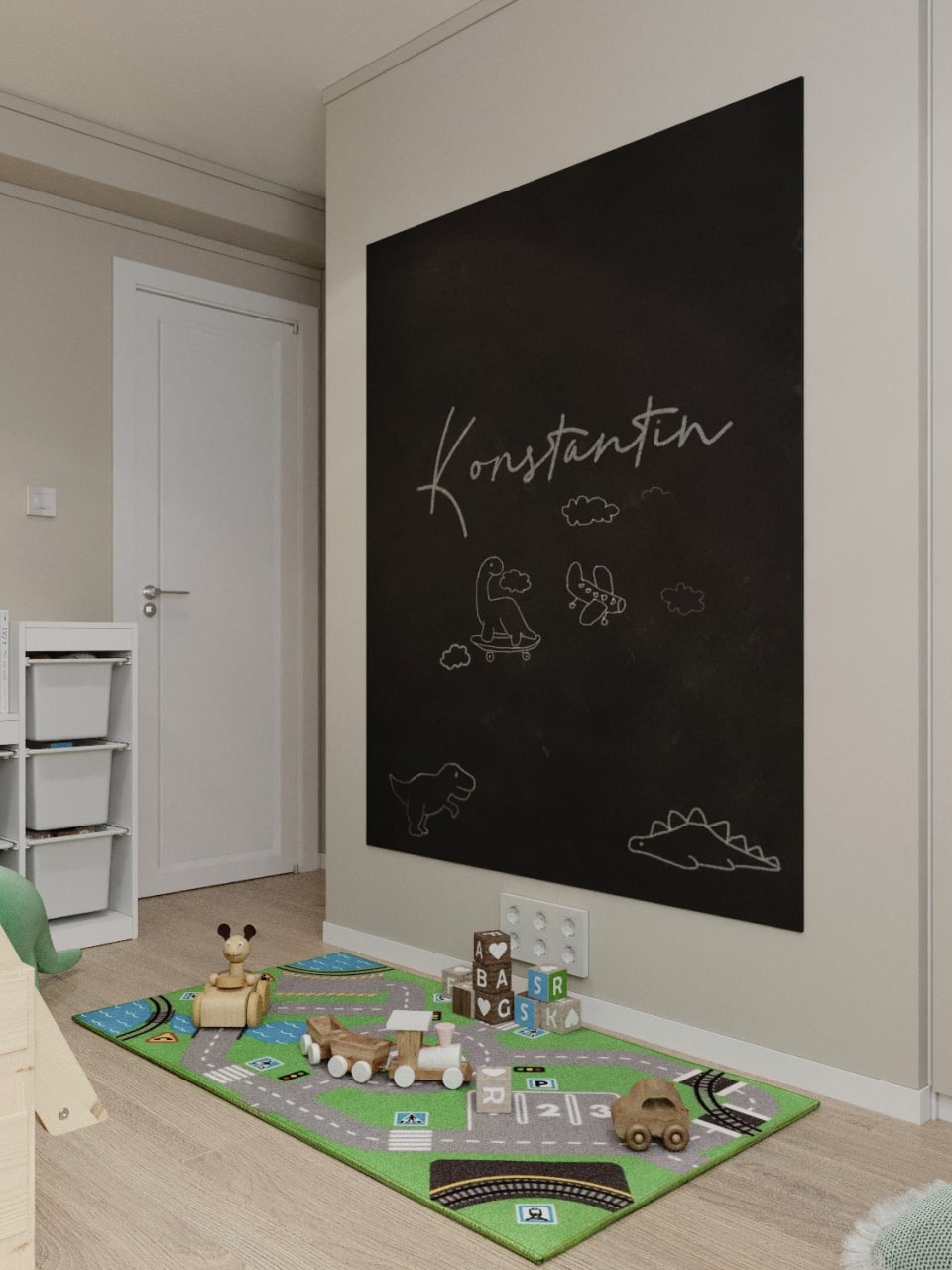 Pokój dziecięcy z czarną tablicą z imieniem 'Konstantin' i rysunkami dinozaurów, drewniane zabawki na dywanie imitującym ulice i tory.