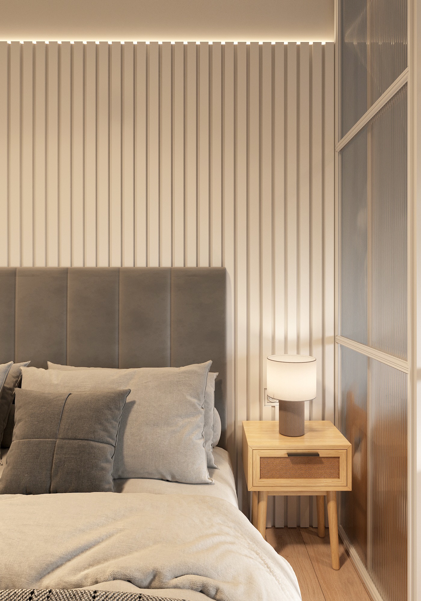 Sypialnia w neutralnych barwach: łóżko z szarym zagłówkiem i poduszkami, drewniana szafka nocna z rattanowym frontem szuflady, lampka i ściana z pionowymi panelami podświetlonymi listwą LED.