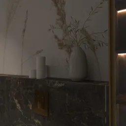 Nowoczesna łazienka z marmurową umywalką, podświetlanym lustrem, minimalistyczną armaturą i dekoracjami w postaci świec i wazonu z gałązkami.