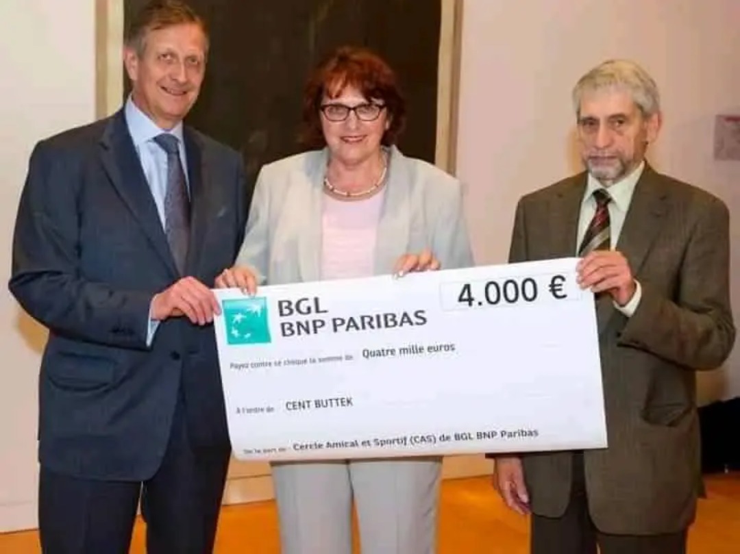 Trzy osoby trzymają czek od BGL BNP Paribas na kwotę 4.000 euro, wręczenie nagrody.