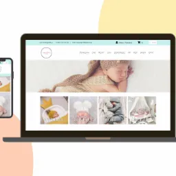 Laptop i smartfon wyświetlające stronę internetową pracowni Agrafka z ofertą dla niemowląt: wyprawka, oferta letnia i zimowa, akcesoria.