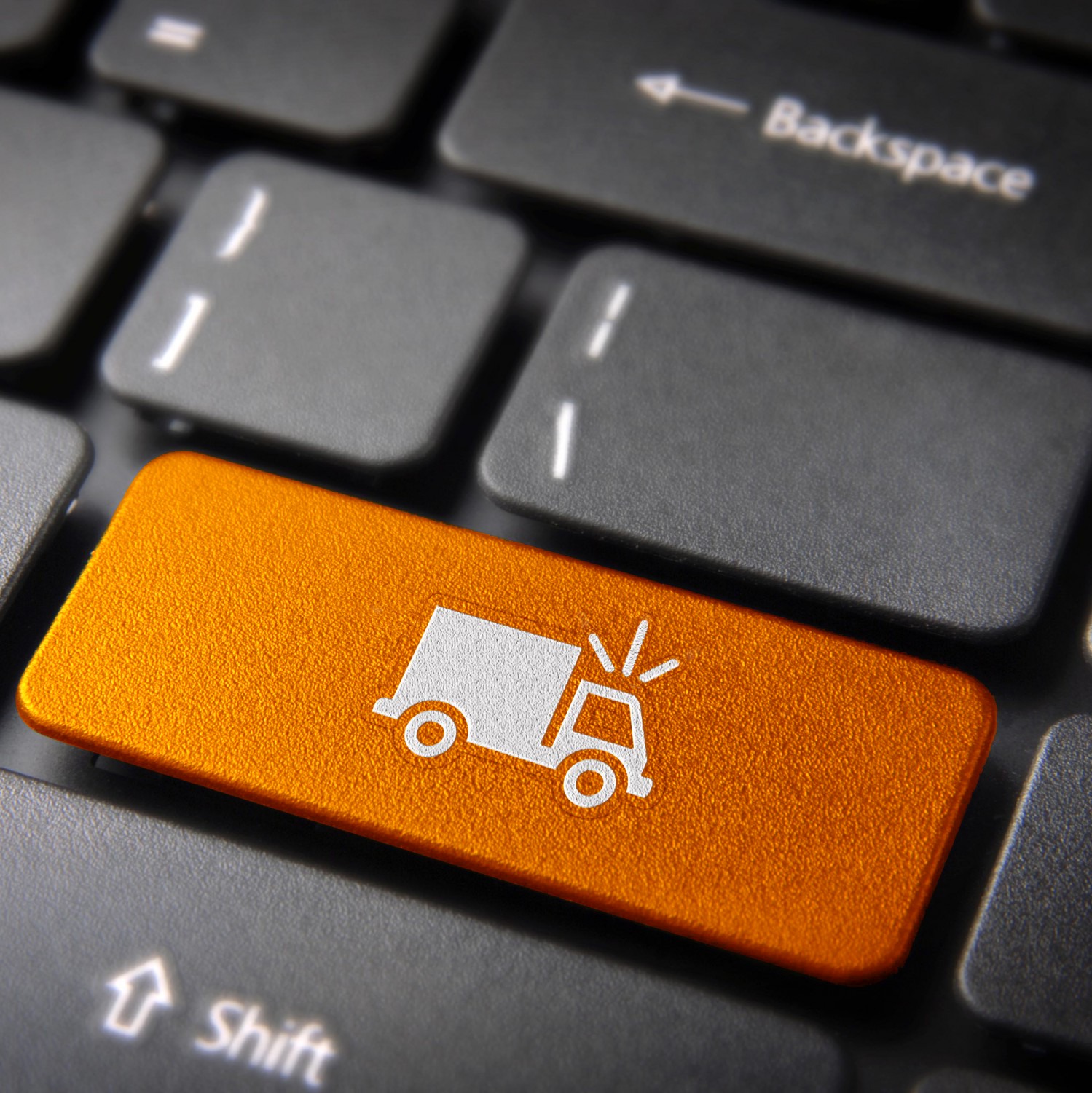 Klawiatura z pomarańczowym klawiszem oznaczonym ikoną ciężarówki z sygnałem dźwiękowym, symbolizującym transport lub dostawę.