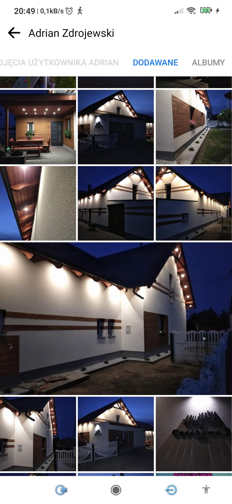 Oświetlenie elewacji domu jednorodzinnego w nocy, z widocznymi lampami punktowymi i drewnianymi elementami dekoracyjnymi, w tle ciemne niebo.