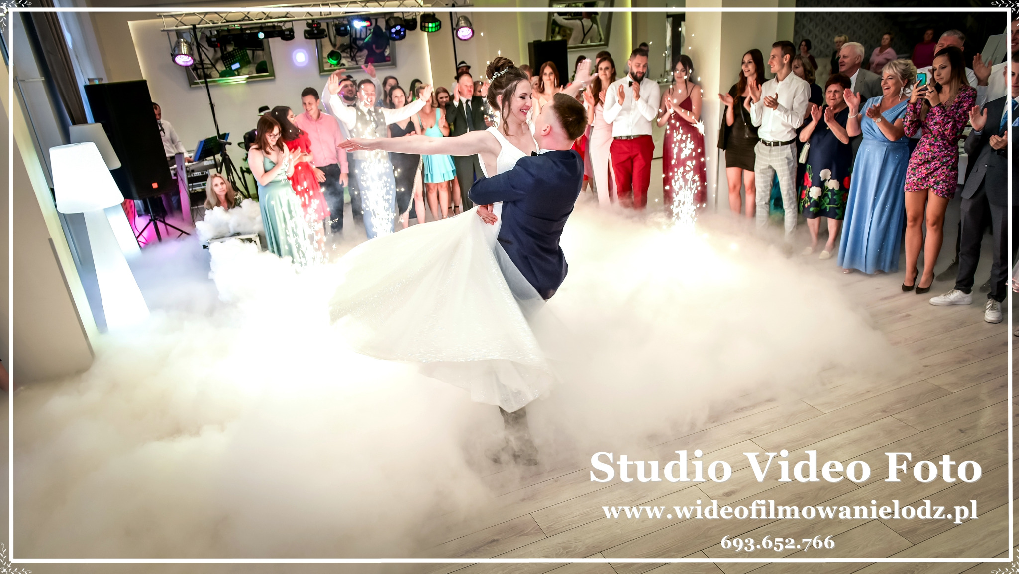 Para młoda w tańcu podczas wesela w Zgierzu, otoczona dymem i iskrami, z gośćmi w tle.