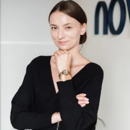 Portret kobiety w czarnym swetrze z zegarkiem na ręce, opierającej brodę na dłoni, z logo firmy w tle.