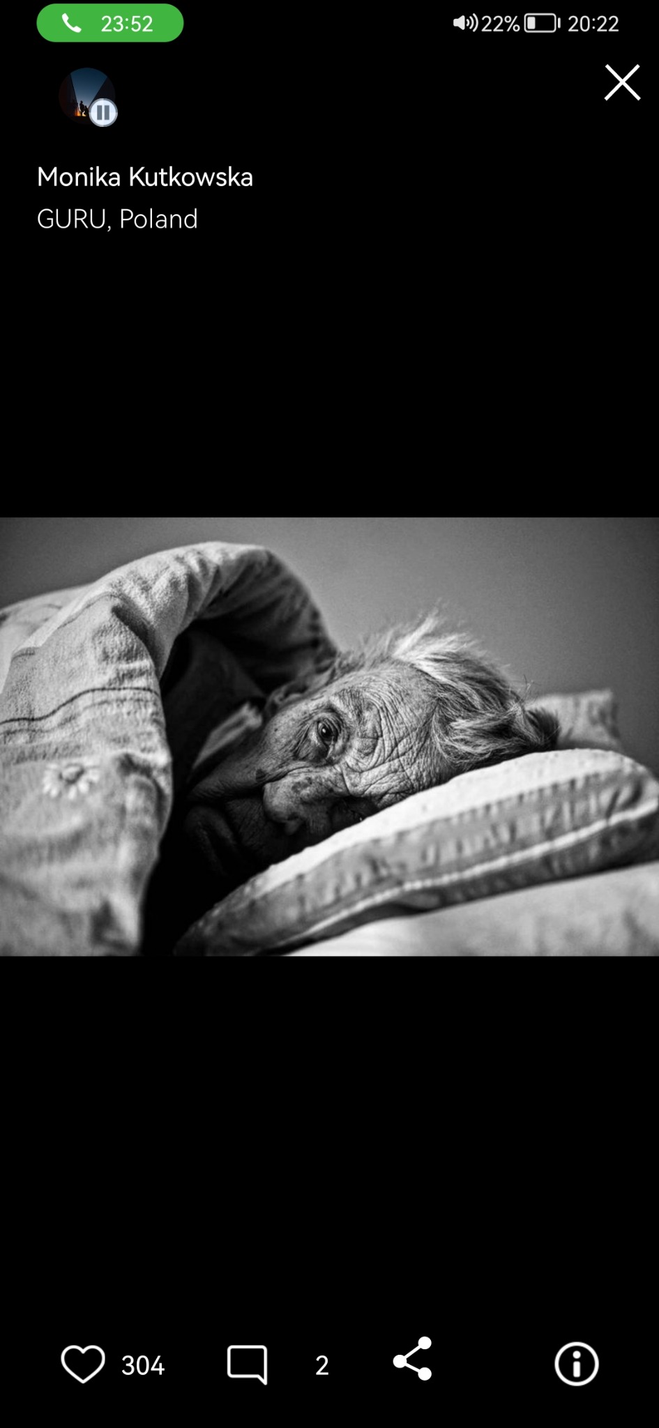 Czarno-białe zbliżenie na twarz starszej kobiety leżącej pod kołdrą, zmarszczki i siwe włosy wyraźnie widoczne, spokojny wyraz twarzy.