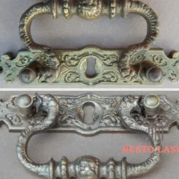 Porównanie dwóch ozdobnych, metalowych uchwytów meblowych: górny po procesie czyszczenia (prawdopodobnie piaskowania lub laserowego), ukazujący jaśniejszy, odświeżony wygląd, a dolny w stanie przed...