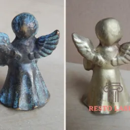 Porównanie dwóch figurek anioła: po lewej stronie figura z brązu pokryta patyną, po prawej figura po usunięciu patyny w Pilawie, ukazująca oryginalny kolor metalu.