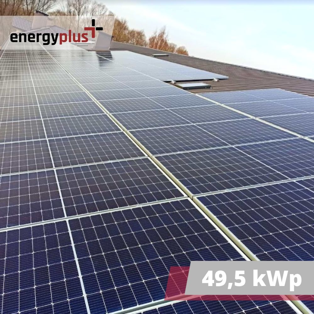 Instalacja paneli słonecznych o mocy 49,5 kWp na brązowym dachu budynku, widok z góry pod kątem, logo firmy w lewym górnym rogu.