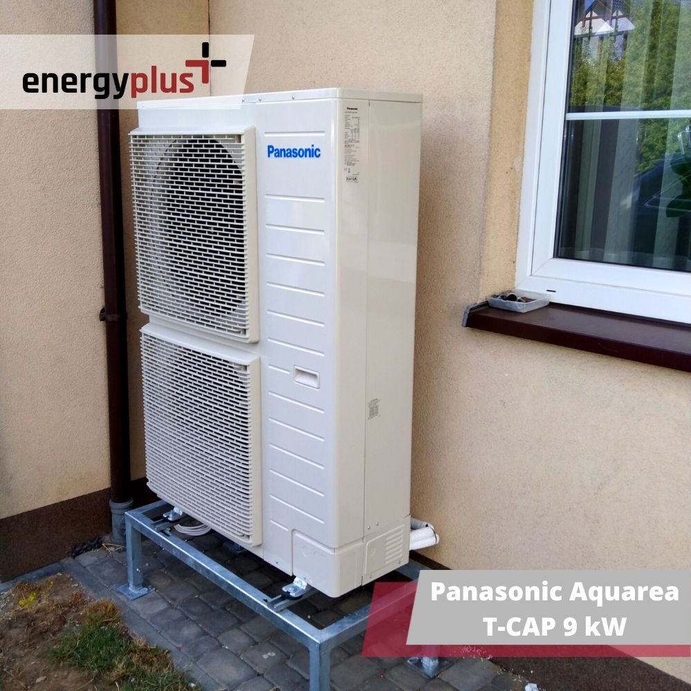 Zewnętrzna jednostka pompy ciepła Panasonic Aquarea T-CAP 9 kW zamontowana na metalowej konstrukcji przy ścianie budynku z oknem.