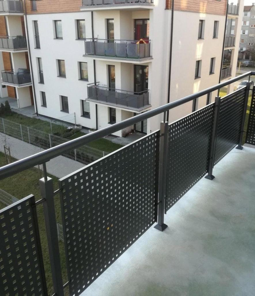 Nowoczesna balustrada balkonowa z metalowych paneli z regularnymi kwadratowymi otworami, widok z góry na budynek mieszkalny z balkonami.