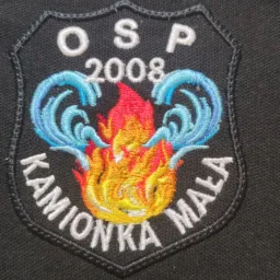 Czarna koszulka polo z wyhaftowanym emblematem OSP Kamionka Mała z motywem płomieni i wody, rok założenia 2008.