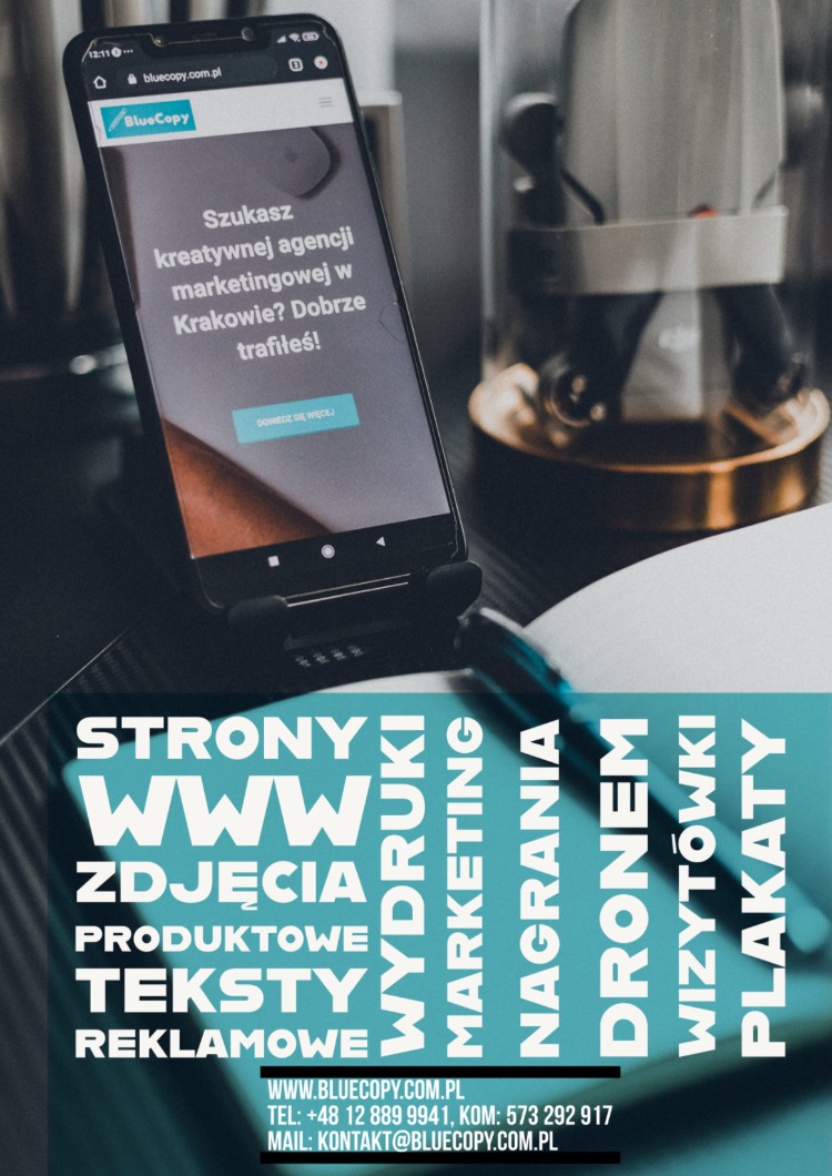 Smartfon w uchwycie prezentuje stronę internetową agencji marketingowej BlueCopy z Krakowa, obok leży długopis i notatnik, w tle widoczny szklany pojemnik.