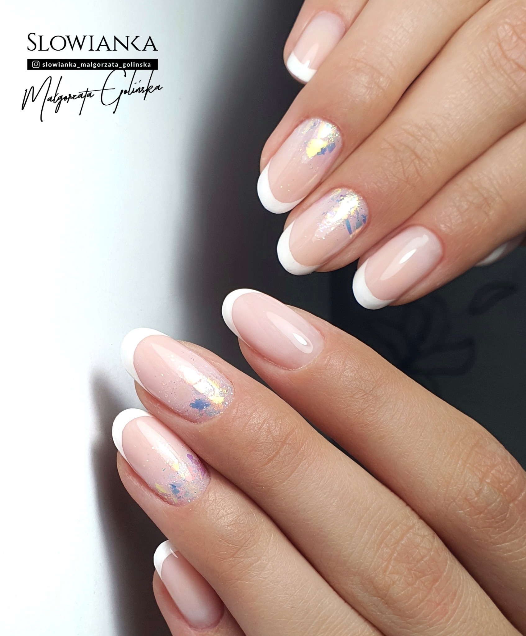 Delikatny french z opalizującymi drobinkami na kilku paznokciach, wykonany na naturalnej płytce, z logo salonu w rogu.