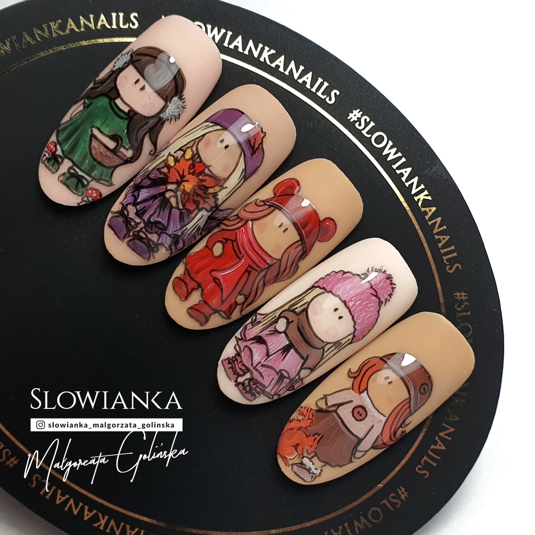 Stylizowane paznokcie z ręcznie malowanymi postaciami dziewczynek w jesiennych strojach, prezentowane na czarnym, okrągłym podłożu z logo marki.
