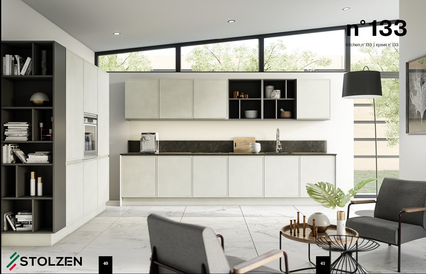 Nowoczesna kuchnia z białymi frontami szafek i ciemnym blatem, uzupełniona o regał z książkami i strefę relaksu z szarymi fotelami i stolikiem kawowym, całość w jasnym, przestronnym wnętrzu...