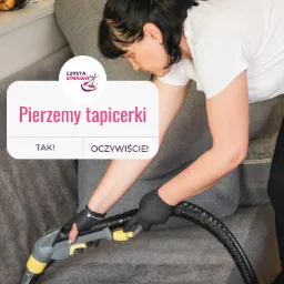 Kobieta w czarnych rękawicach czyści szarą tapicerkę sofy za pomocą odkurzacza piorącego z żółtymi elementami, widoczny wąż i logo firmy na winietce.