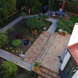 Kraina ogrodow - Uliana Kozak, Rostjslav Holodniak Spółka cywilna - Widok z góry na zagospodarowany ogród z ceglanym tarasem i ścieżkami żwirowymi, mały trawnik z meblami ogrodowymi w tle.